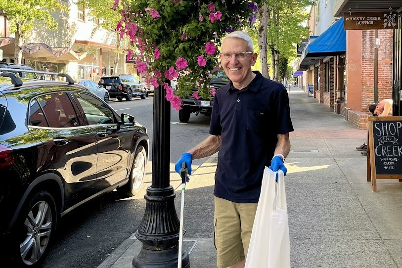 Steve Loosley picking up litter on a downtown Roseburg sidewalk during the Thrive Umpqua cleanup